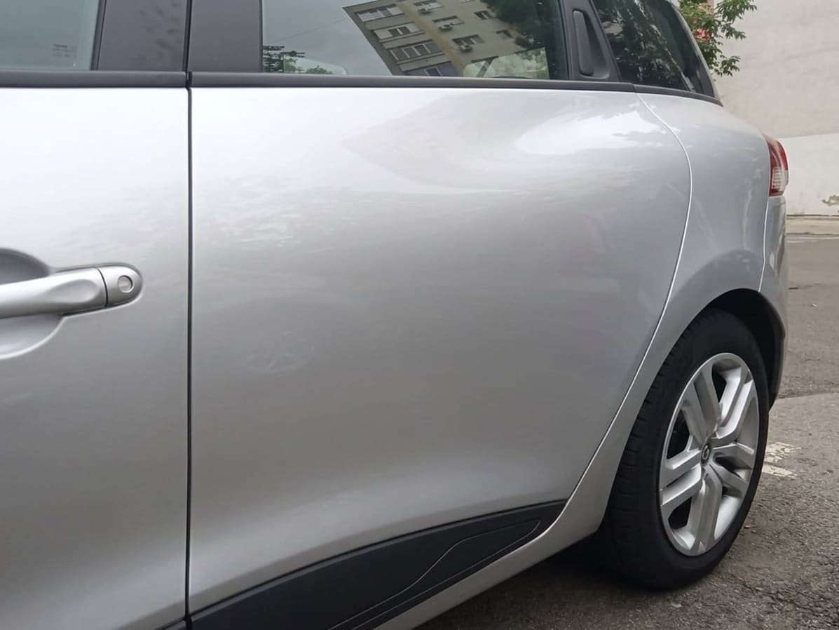 Renault Clio argintiu cu ușa din spate îndreptată și vopsită, după reparație în atelierul GSC