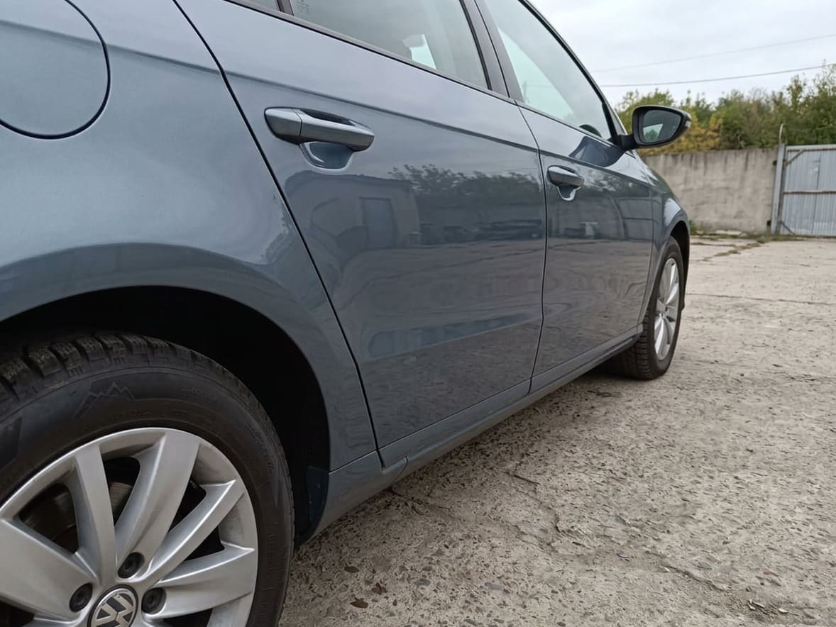 Volkswagen sedan gri-albastru cu aripa și ușa din spate vopsite, după reparație în atelierul GSC
