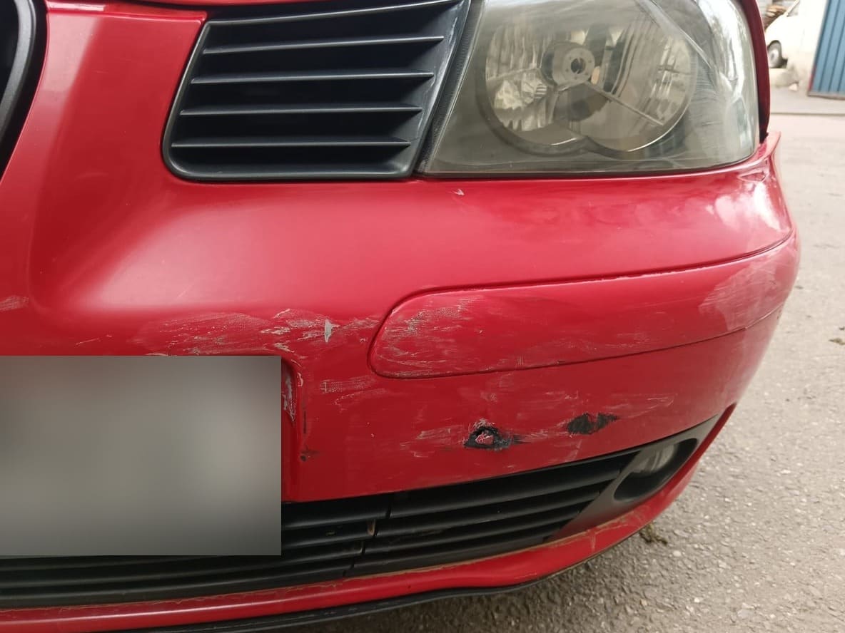 Seat roșu cu bara din față zgâriată și fisurată, înainte de reparație